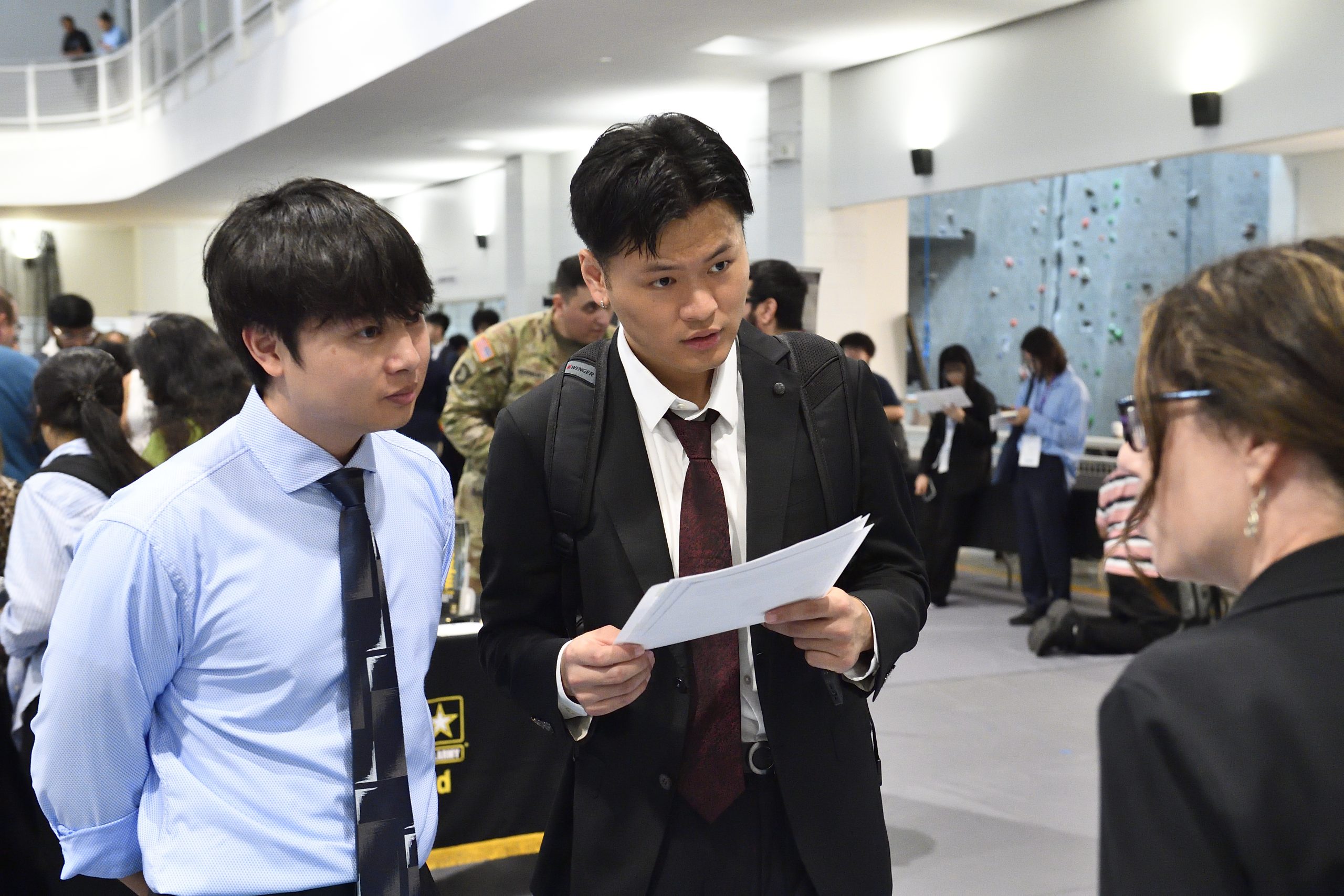 two male students talking to an employer at the career fair.