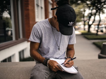 A person taking notes outside.