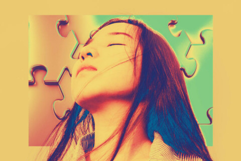 A long haired person with closed eyes appears against a puzzle piece background