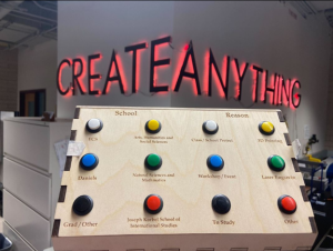 Wooden box with buttons to indicate a visitor's intent in coming to Innovation Labs. Letters on the wall spell out "Create Anything."
