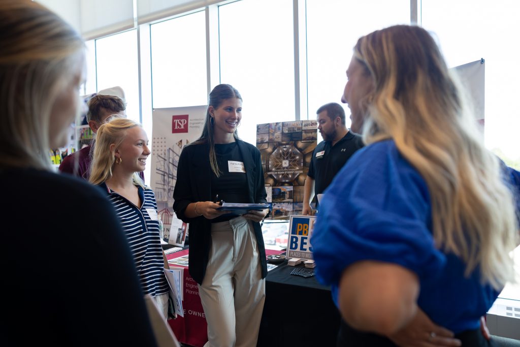 Students and recruiters talking with each other at a career fair.