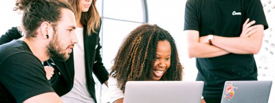 four people looking at laptops