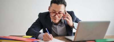 Man working at a desk while talking on the phone