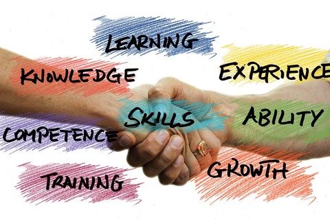 Close up of two people shaking hands with the words: learning, knowledge, competence, skills, training, growth, ability, experience