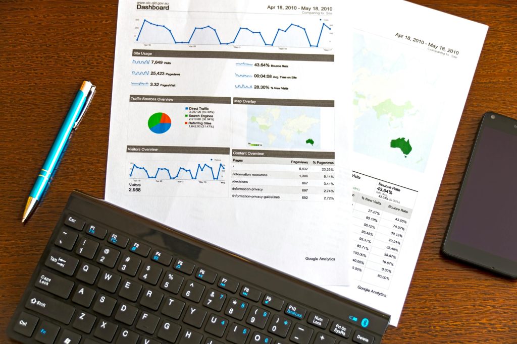 image of bar charts on desk with keyboard, phone and pen
