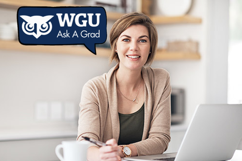A woman sitting down at a desk with a pen in her hand. She has a laptop in front of her and is smiling at the camera. There is a logo for WGU Ask A Grad on the top left corner.