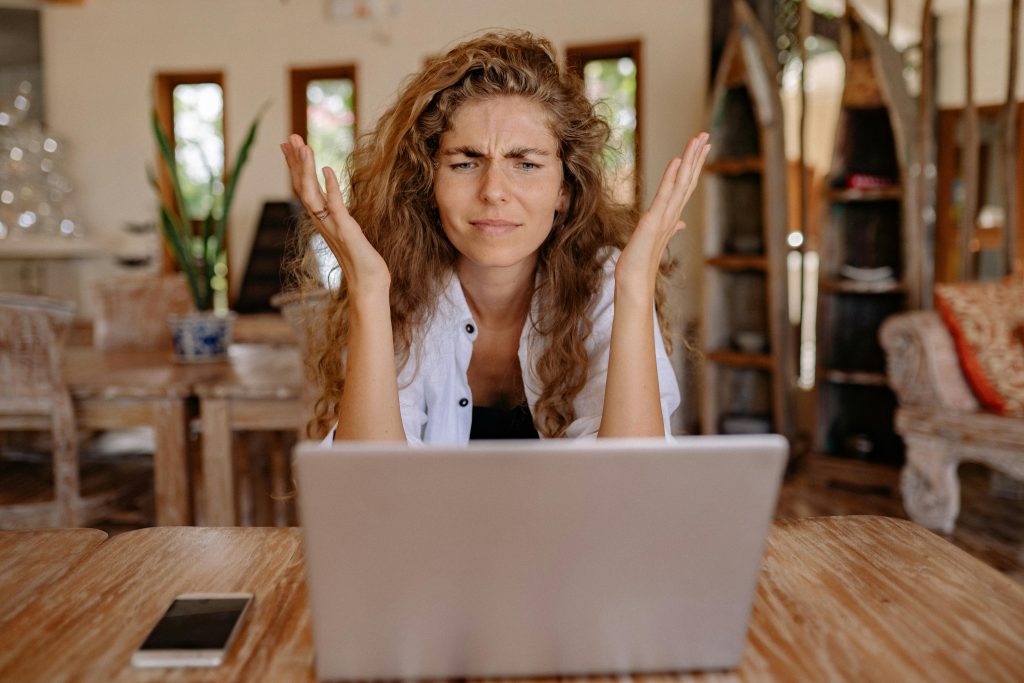 Woman sitting in front of laptop looking confused/frustrated