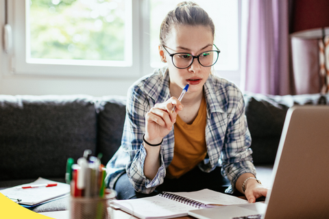a woman sits and stares at a computer screen