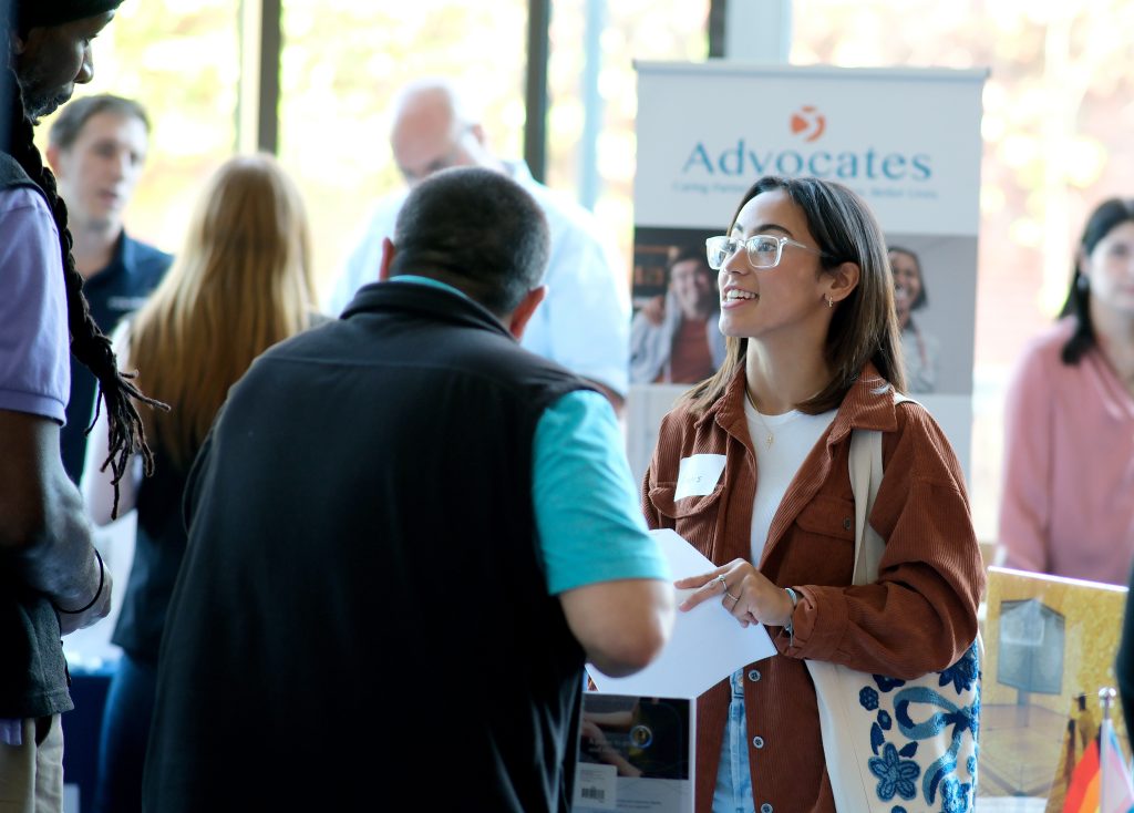 female college student speaks to an employer at a career fair
