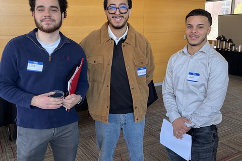 three smiling students dressed professionally