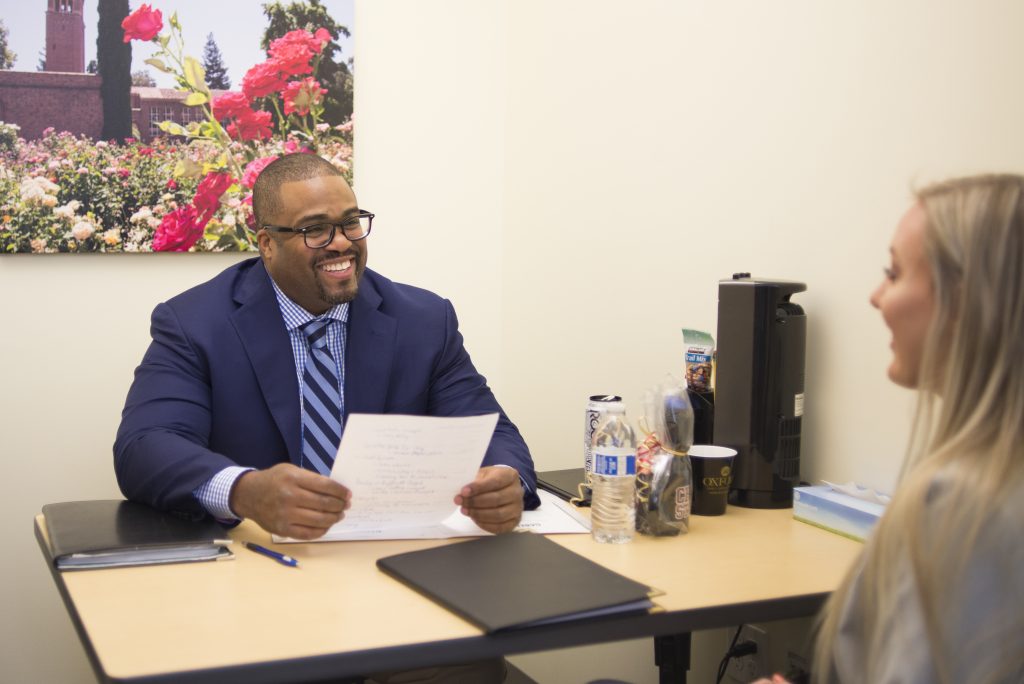 An employer interviews a student in a private interview room.
