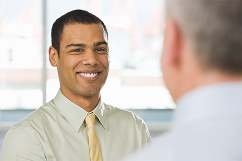 Image of Young Intern smiling at Mature Businessman