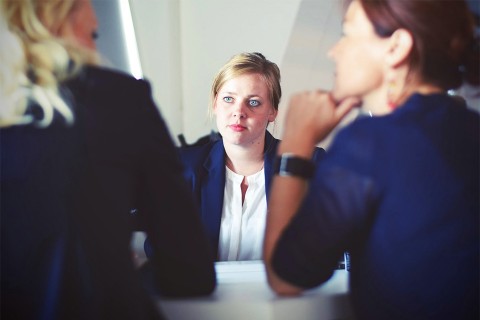 Three employees of a company in a meeting.
