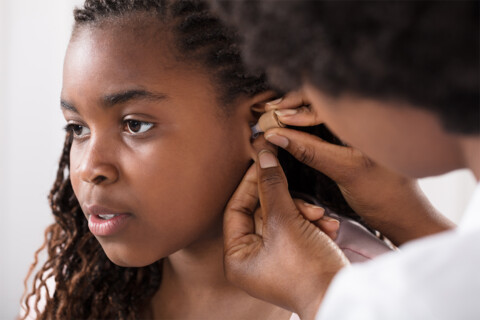 Clinical Audiologist examining a patient's ear.