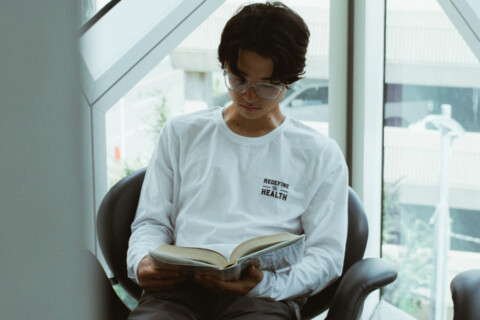 Student reading a hard cover book.