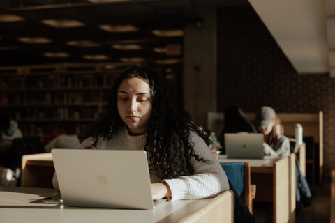 Student studying at Babbidge library, on their laptop