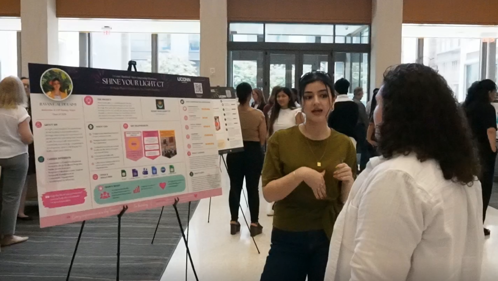 Student talking to faculty about micro-internship presentation