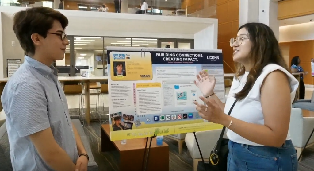 Student talking to faculty about micro-internship presentation