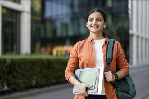 Adobe stock image of confident student holding school supplies