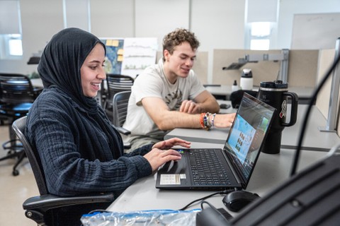 MediaShare photo of alumni at a desk