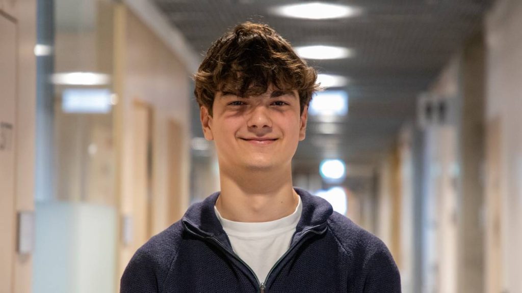 Asen smiling in a hallway