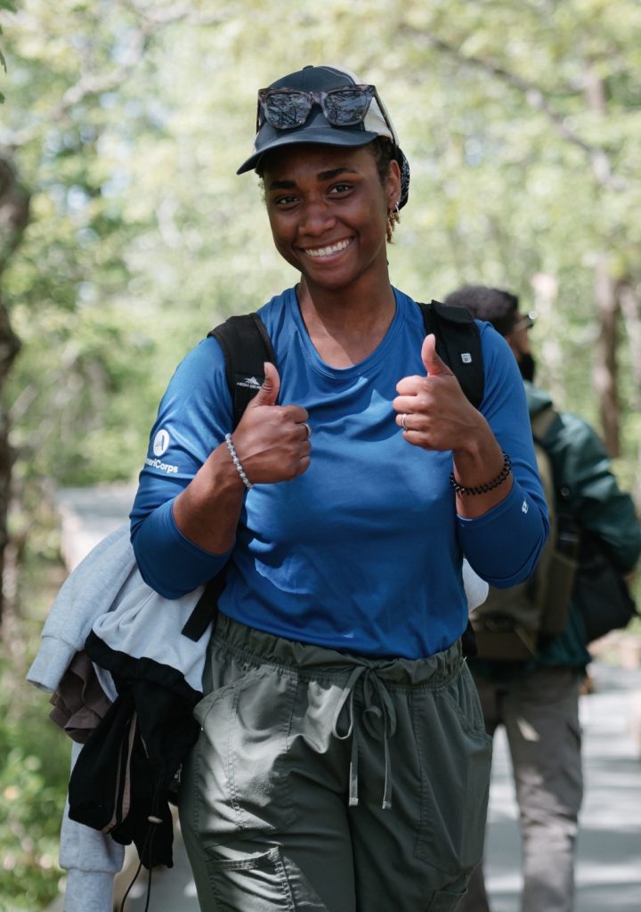 Hannah Carden giving thumb up signs while hiking at summer internship.